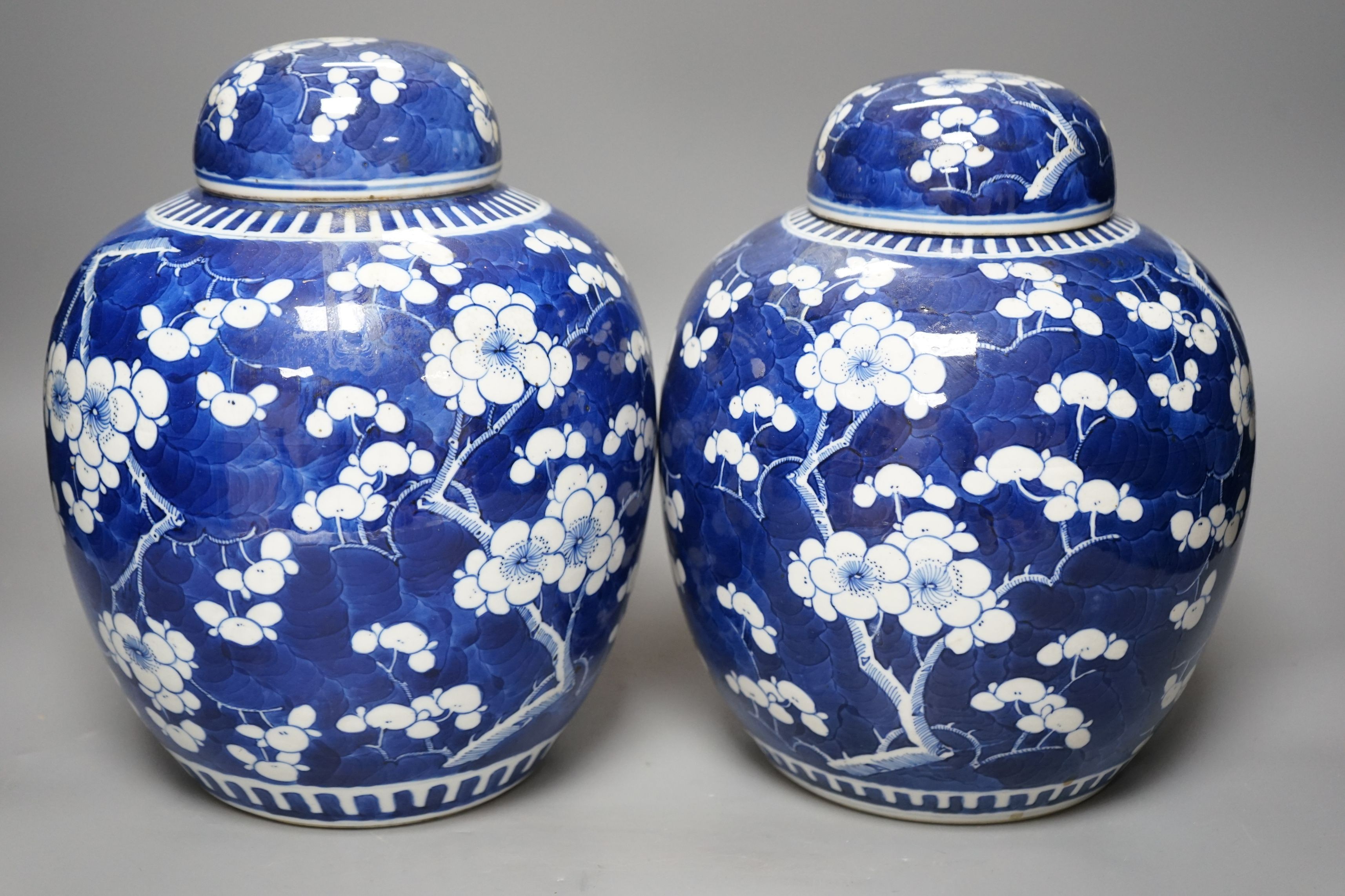 Two Chinese 20th century prunus jars and covers, 27cms high